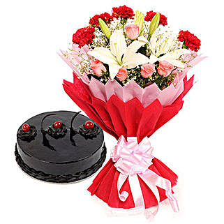 Enchanted Bloom - Bunch of 2 White Asiatic Lilies, 5 Red Carnations and 5 Pink Roses in a two layer paper packing and half kg chocolate truffle cake
