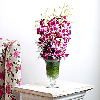 Glass vase arrangement of 10 purple orchids