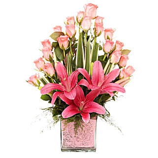Glass vase arrangement of 20 pink roses, 3 pink asiatic lilies, draceane leaves, and vase filler